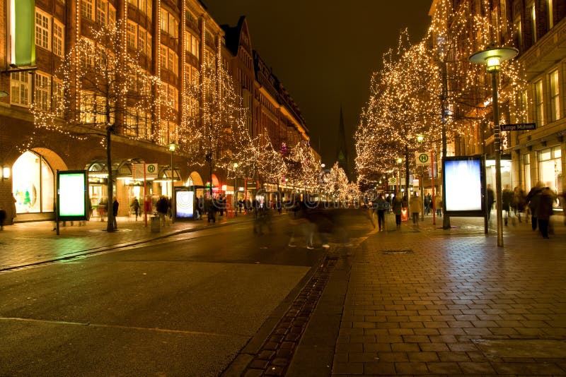 Las luces en árboles lo largo de calles por la noche.