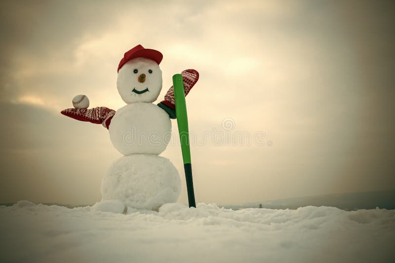 Christmas snowman in cap with baseball bat in winter stock image Christmas snowman in cap with baseball bat in winter stock image