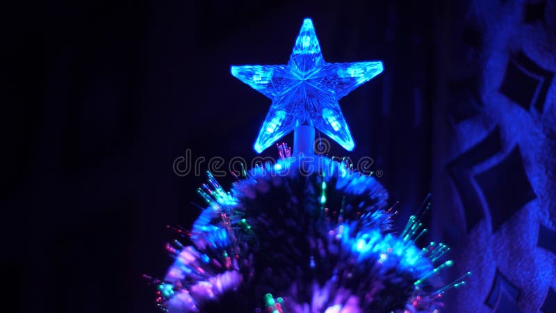 Christmas Star Glows With Colored Lights On Christmas Tree