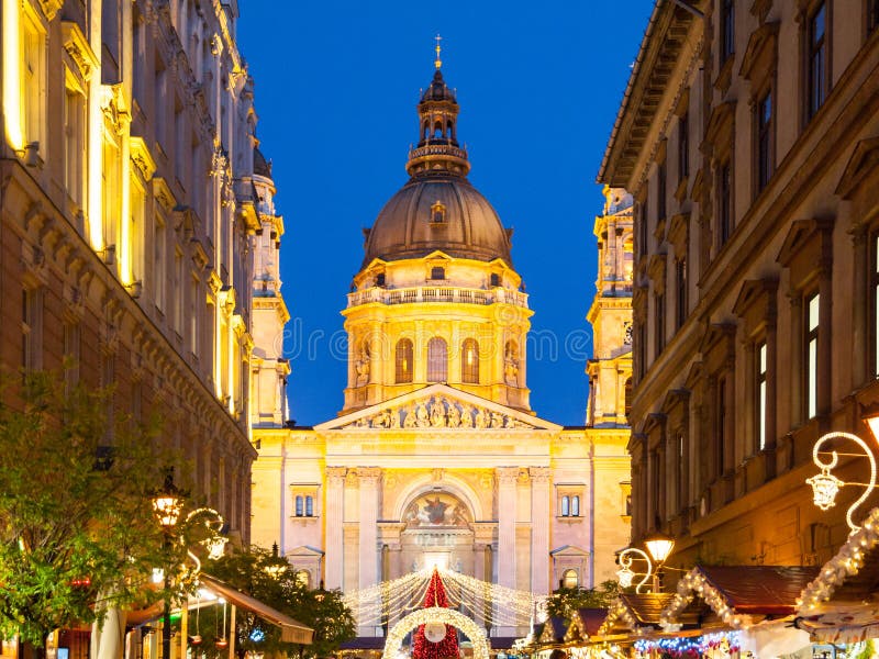 Christmas time in Budapest. Illuminated dome of Saint Stephen`s Basilica with holiday street decoration by night