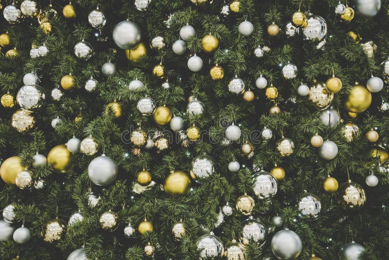 Christmas tree background, Gold and silver balls hanging on the green Christmas tree closeup