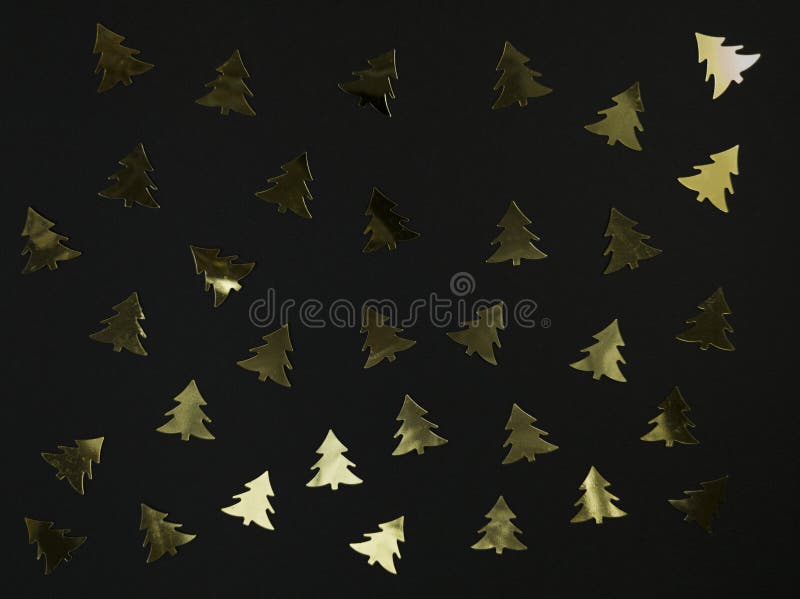 Christmas tree confetti on a black background. Festive flat lay royalty free stock photos