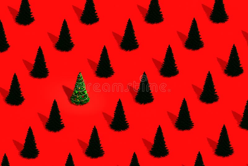 Christmas tree decorated with Christmas toys among number of ordinary fir trees. The concept of uniqueness. Pattern from