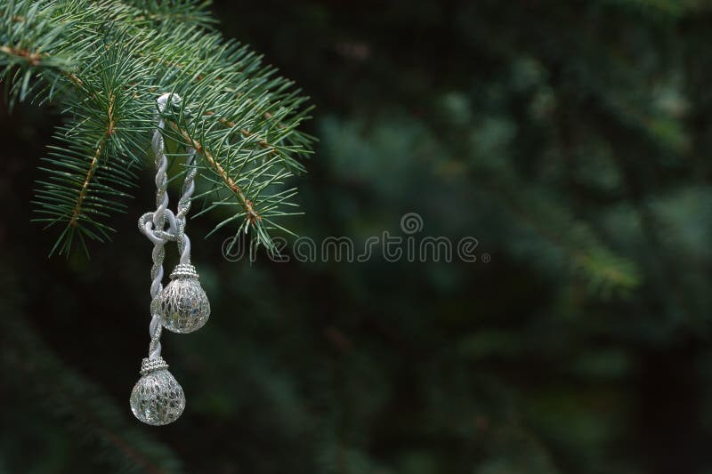 The Christmas-tree decoration hangs on a branch