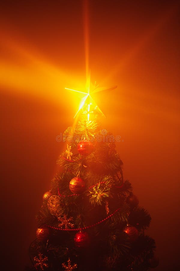 Christmas Tree with Festive Lights, Orange Background Stock Photo
