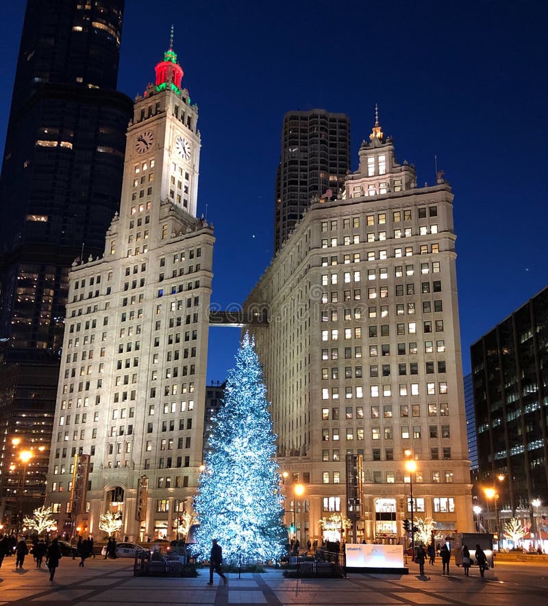 This is a Winter picture of the iconic Wrigley Building Towers lighted for the holidays framing a Christmas Tree on Pioneer Court located in Chicago, Illinois in Cook County. This picture was taken on December 6, 2018. This is a Winter picture of the iconic Wrigley Building Towers lighted for the holidays framing a Christmas Tree on Pioneer Court located in Chicago, Illinois in Cook County. This picture was taken on December 6, 2018.