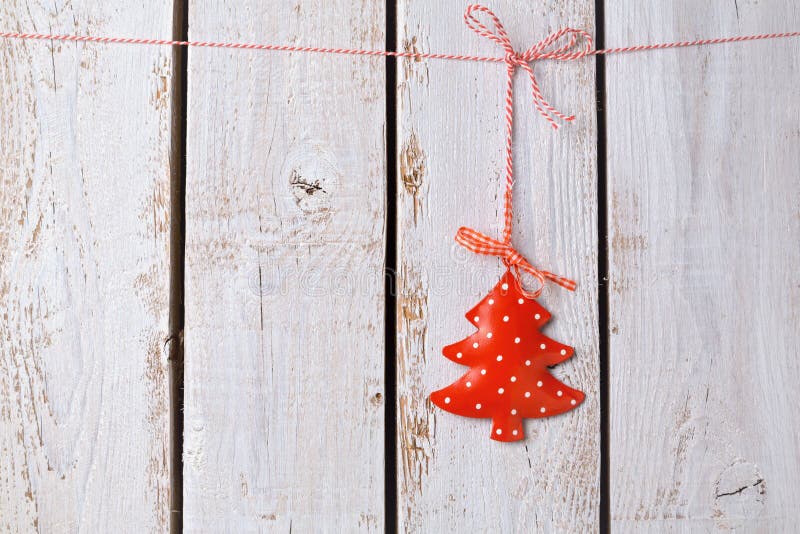 Christmas tree ornament hanging over white wooden background