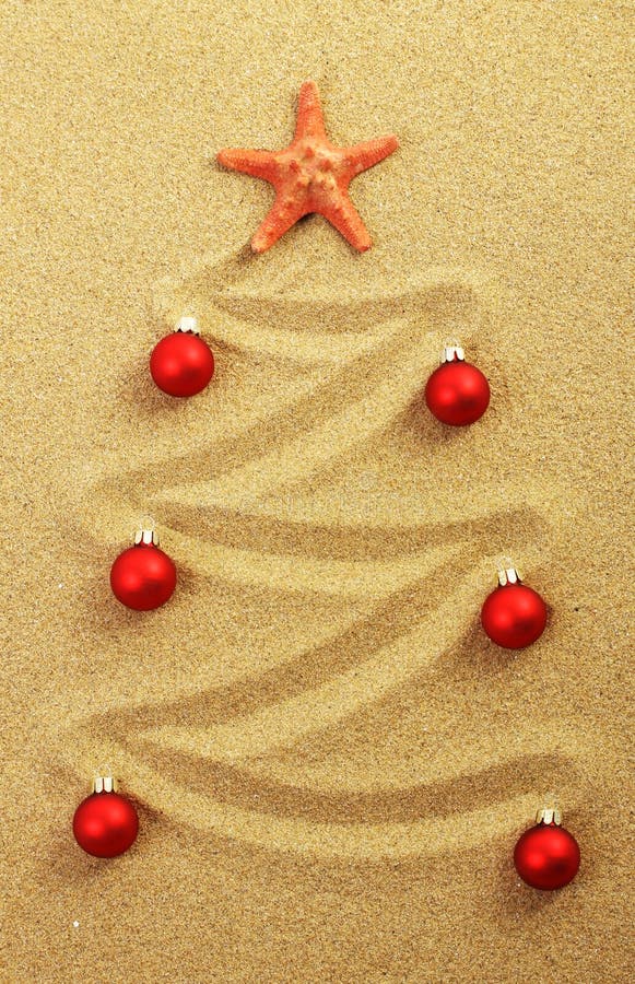 Christmas tree on painting in sand with red starfish and red matt christmas balls