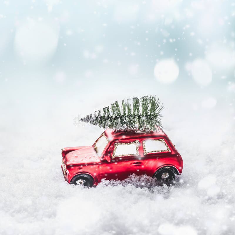 Christmas tree on red toy retro car in snow, through snowy winter wonder land with snowfall and bokeh. royalty free stock images Christmas tree on red toy retro car in snow, through snowy winter wonder land with snowfall and bokeh. royalty free stock images