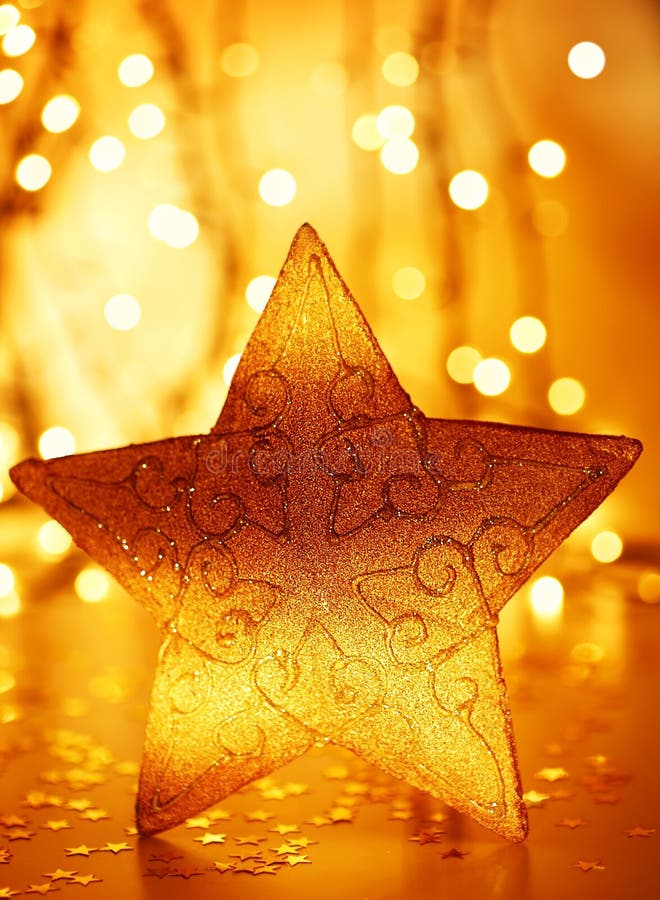 Christmas tree star decoration with winter ornament as holiday background over abstract defocus golden lights