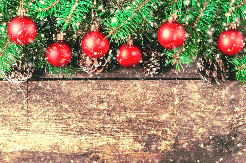 Branches of a Christmas tree on old boards. Christmas background. Christmas decorations. New Year background. Xmax background. Toned image. Falling Snow. Branches of a Christmas tree on old boards. Christmas background. Christmas decorations. New Year background. Xmax background. Toned image. Falling Snow.