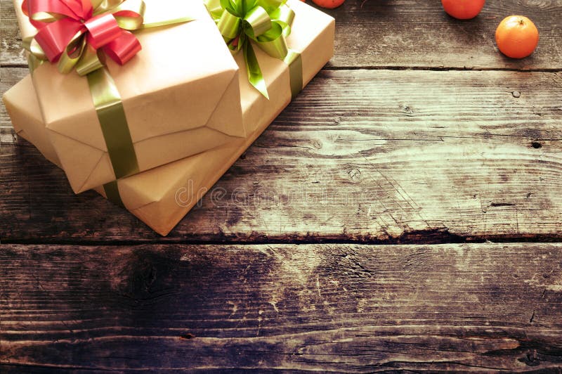 Gifts boxes on the old dark boards. Christmas background. Christmas decorations. New Year background. Xmax background. Selective focus on a bow-knot. Small depth of field. Toned image. Gifts boxes on the old dark boards. Christmas background. Christmas decorations. New Year background. Xmax background. Selective focus on a bow-knot. Small depth of field. Toned image.