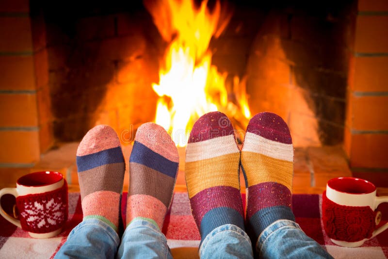 Christmas Xmas Family Holiday Winter. Family in Christmas socks near fireplace. Mother; father and baby having fun together. People relaxing at home. Winter stock image