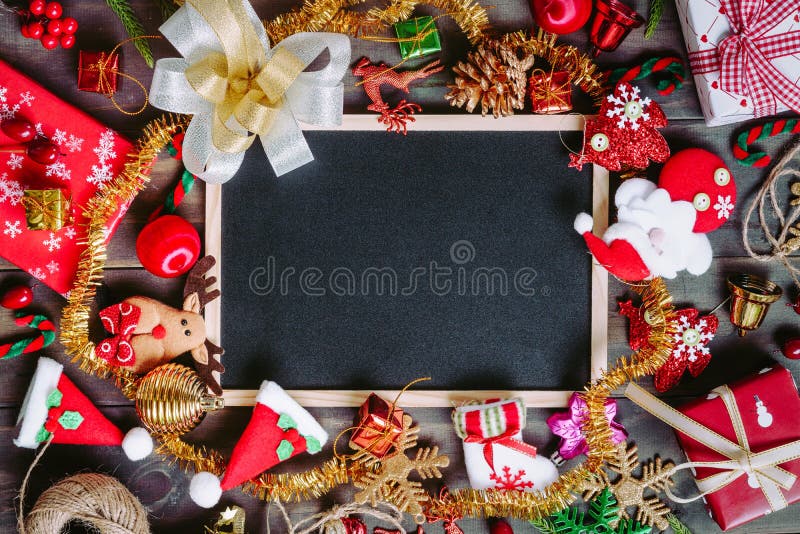 Christmas Xmas New Year holiday background with empty black chalkboard for your text and various festive decorations. blank chalk. Board surrounded of christmas royalty free stock photography