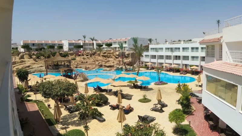 Chronologie du resort avec piscine bleue, parasols et transats en Egypte