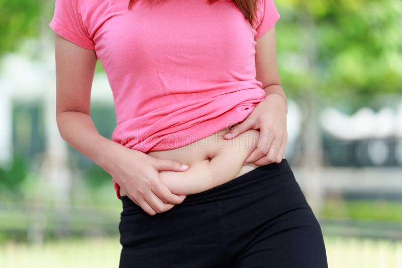 Chubby woman hand holding her own belly fat at outdoor.