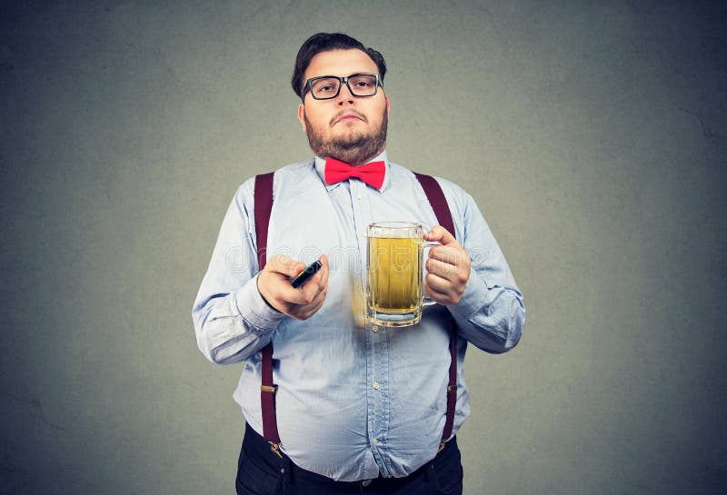 Chubby άτομο με την μπύρα και TV μακρινή στοκ εικόνες Chubby άτομο με την μπύρα και TV μακρινή στοκ εικόνες
