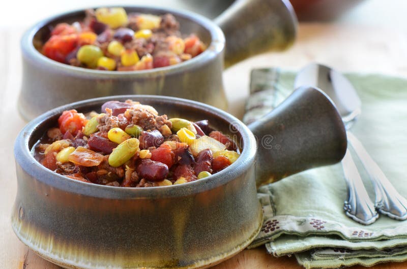 Hearty bowls of chuckwagon chili con carne with beef, beans, corn and tomato