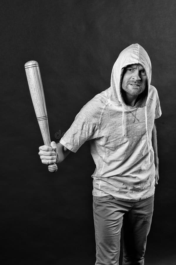 Chuligański odzież kapiszon w hoodie tshirt Brodaty mężczyzna chwyta kij bejsbolowy Gangsterski facet zagraża z nietoperz bronią fotografia stock Chuligański odzież kapiszon w hoodie tshirt Brodaty mężczyzna chwyta kij bejsbolowy Gangsterski facet zagraża z nietoperz bronią fotografia stock