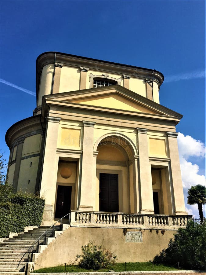 The church of Saint Charles in Arona was designed by architect Francesco Maria Richini and built starting from 1614. History, architecture and art, blue sky and sunny day, stairs, balcony, trees, ancient building and beauty, elegance and refinement, religion and worship, devotion and tradition. The church of Saint Charles in Arona was designed by architect Francesco Maria Richini and built starting from 1614. History, architecture and art, blue sky and sunny day, stairs, balcony, trees, ancient building and beauty, elegance and refinement, religion and worship, devotion and tradition