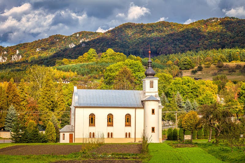 Church in Sulov - Hradna with background of Sulov rocks at autum