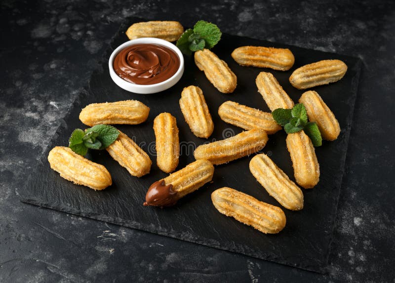 Churros z czekoladowym maczanie kumberlandem cynamonu cukier fotografia stock Churros z czekoladowym maczanie kumberlandem cynamonu cukier fotografia stock