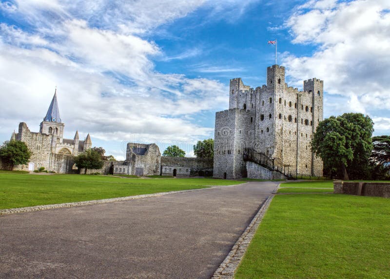 Rocherster (UK) castle and grounds at summer with blue cloudy skies and Union Jack flag flying. Rocherster (UK) castle and grounds at summer with blue cloudy skies and Union Jack flag flying.