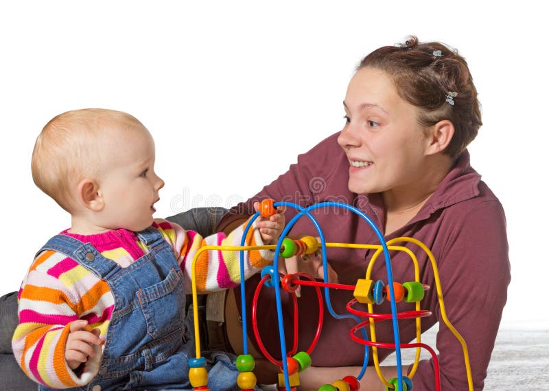 Baby with motor activity development delay being stimulated to develop coordination and muscle control and movement on a bead maze by an adoring mother. Baby with motor activity development delay being stimulated to develop coordination and muscle control and movement on a bead maze by an adoring mother