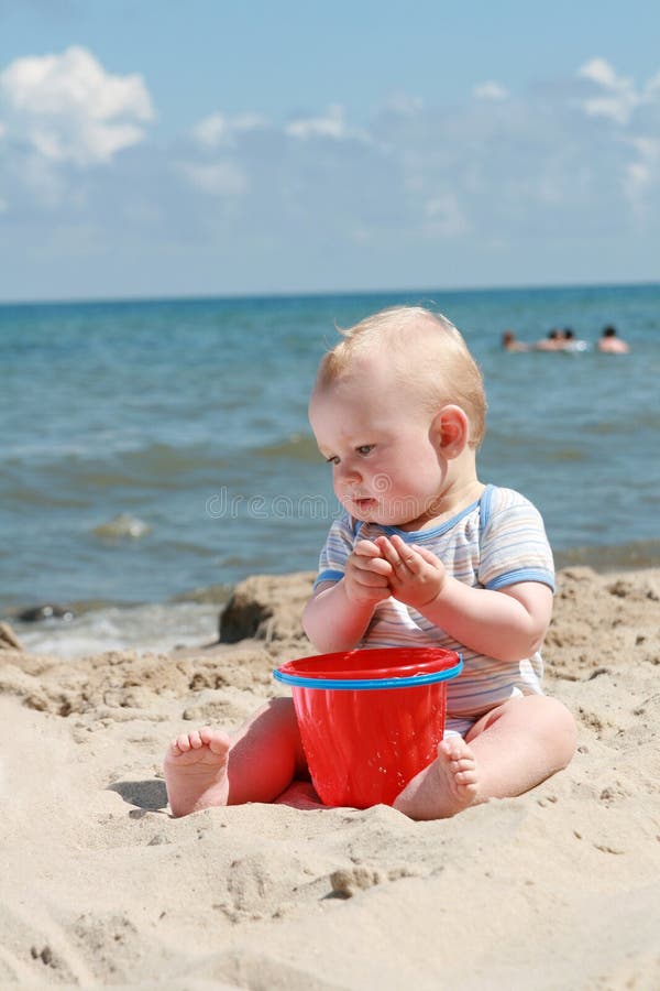 8 months old baby boy playing on a beach. 8 months old baby boy playing on a beach