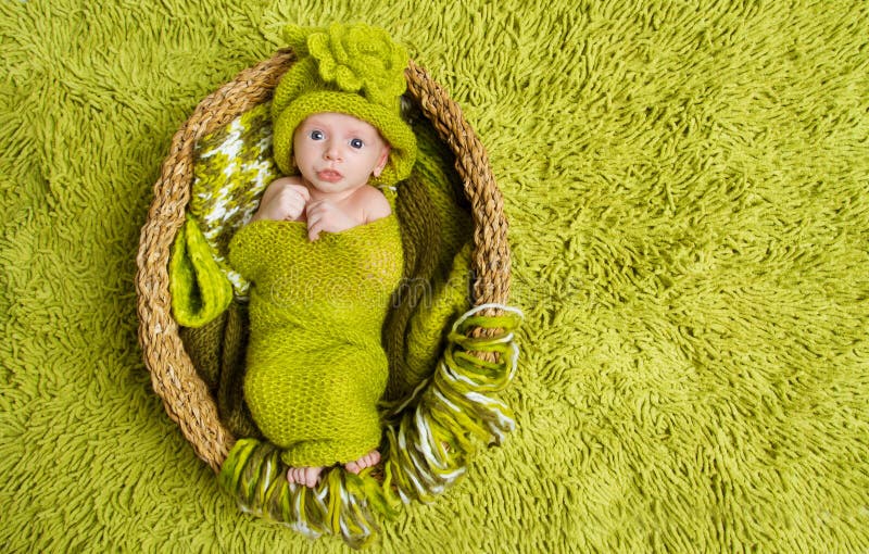 Chéri nouveau-née dans le chapeau vert de laine à l'intérieur du panier photo libre de droits Chéri nouveau-née dans le chapeau vert de laine à l'intérieur du panier photo libre de droits