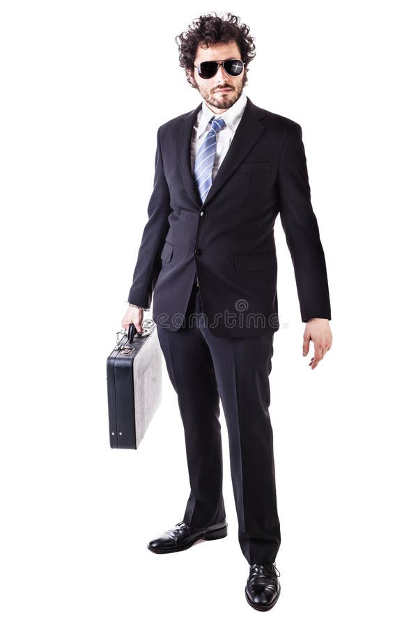Businessman wearing a suit with a secure suitcase attached with handcuffs isolated over a white background. Businessman wearing a suit with a secure suitcase attached with handcuffs isolated over a white background