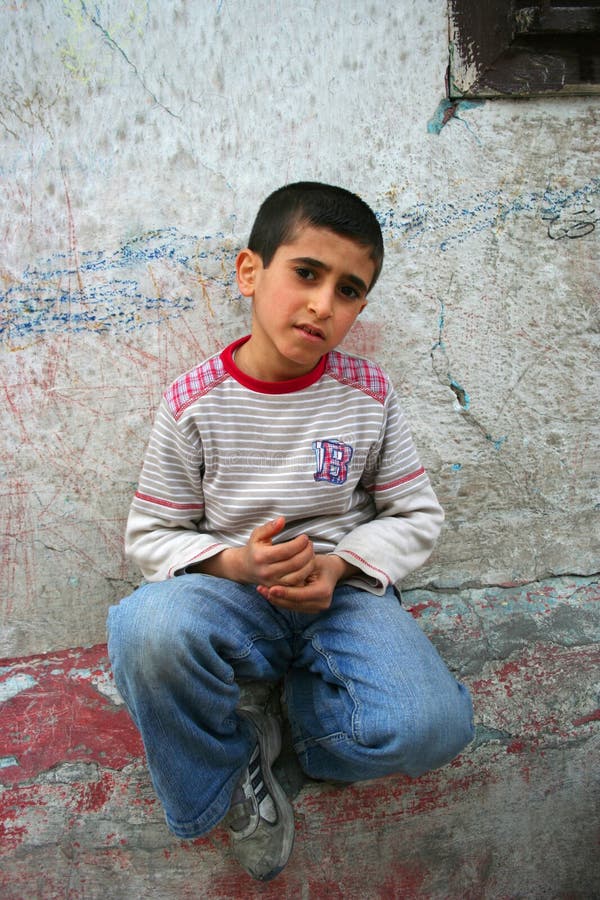 Cute boy sitting on the dirty wall. Cute boy sitting on the dirty wall