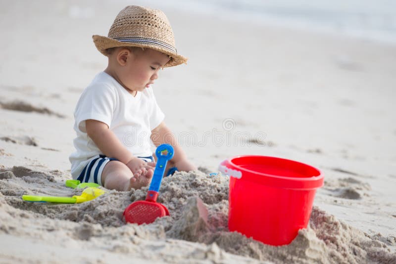 Chłopiec bawić się z piaskiem na tropikalnej plaży obrazy stock Chłopiec bawić się z piaskiem na tropikalnej plaży obrazy stock