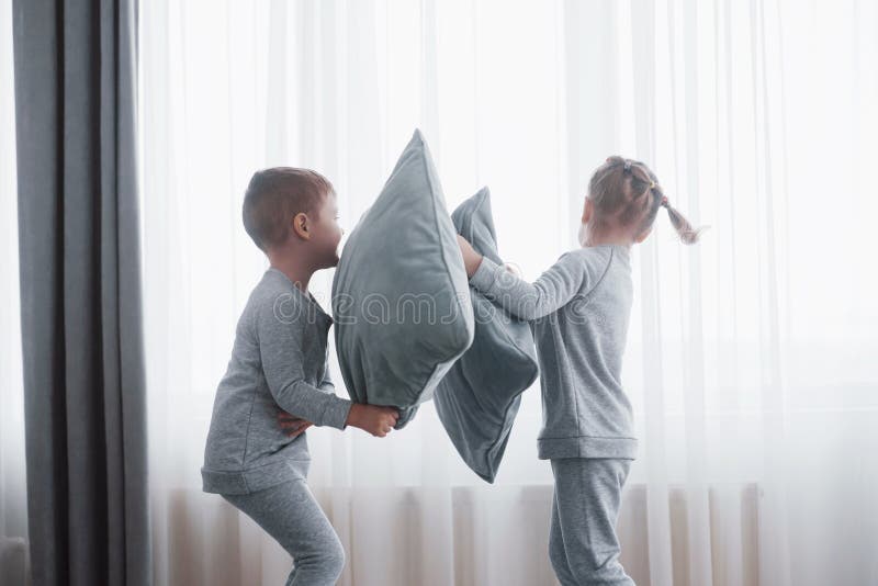 Chłopiec i dziewczyna reżyserowaliśmy poduszki walkę na łóżku w sypialni Niegrzeczni dzieci biją inne poduszki each Lubią