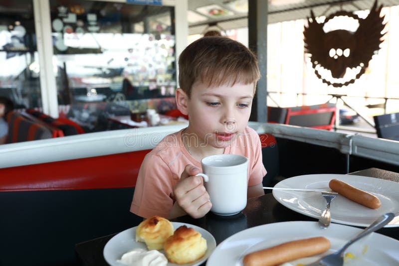 Chłopiec pijący herbatę w restauracji. Portret chłopca pijącego herbatę w restauracji