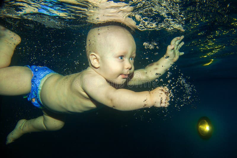 Chłopiec uczenie pływać podwodnego w pływackim basenie