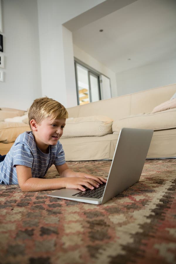 Chłopiec używa laptop w żywym pokoju zdjęcia royalty free