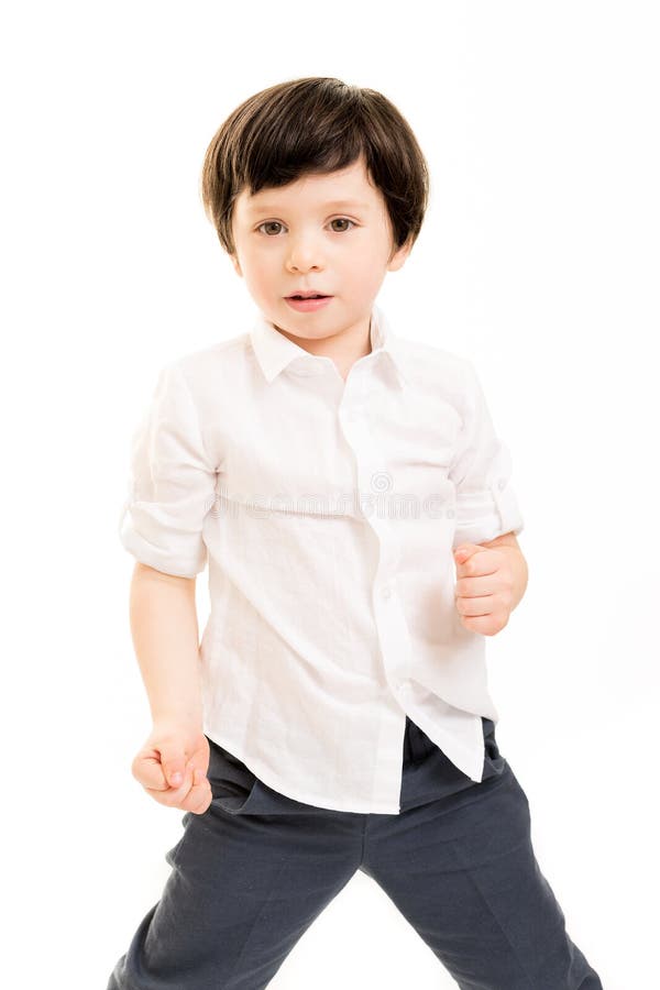 Portrait of a little boy in a white shirt in a fighting pose against a white background. Portrait of a little boy in a white shirt in a fighting pose against a white background