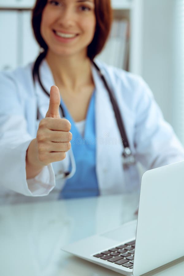 Ci?rrese para arriba de los pulgares femeninos del doctor para arriba M?dico moreno sonriente alegre feliz listo para examinar al fotos de archivo libres de regalías Ci?rrese para arriba de los pulgares femeninos del doctor para arriba M?dico moreno sonriente alegre feliz listo para examinar al fotos de archivo libres de regalías