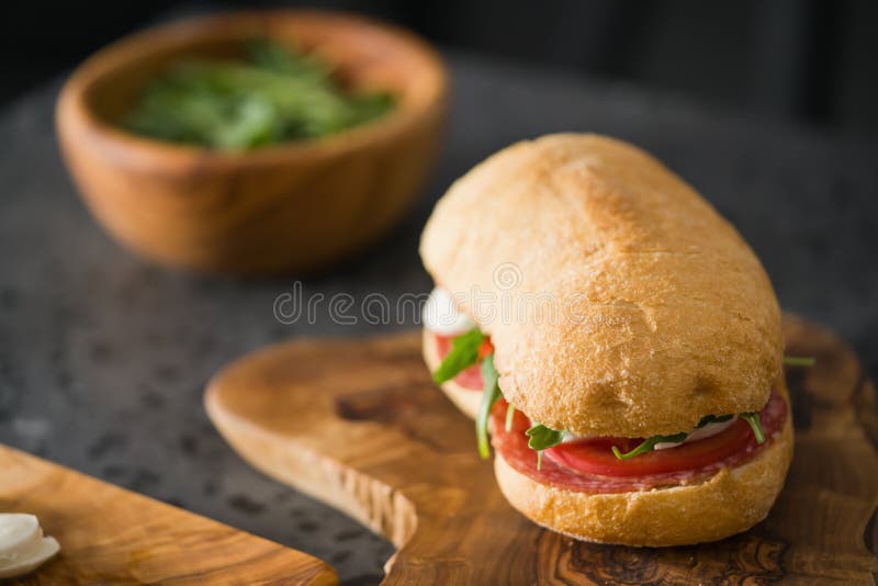 Ciabatta Sandwich with Salami and Mozzarella Cheese on Olive Board