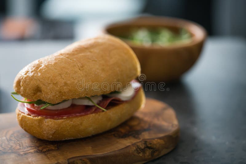 Ciabatta Sandwich with Salami and Mozzarella Cheese on Olive Board