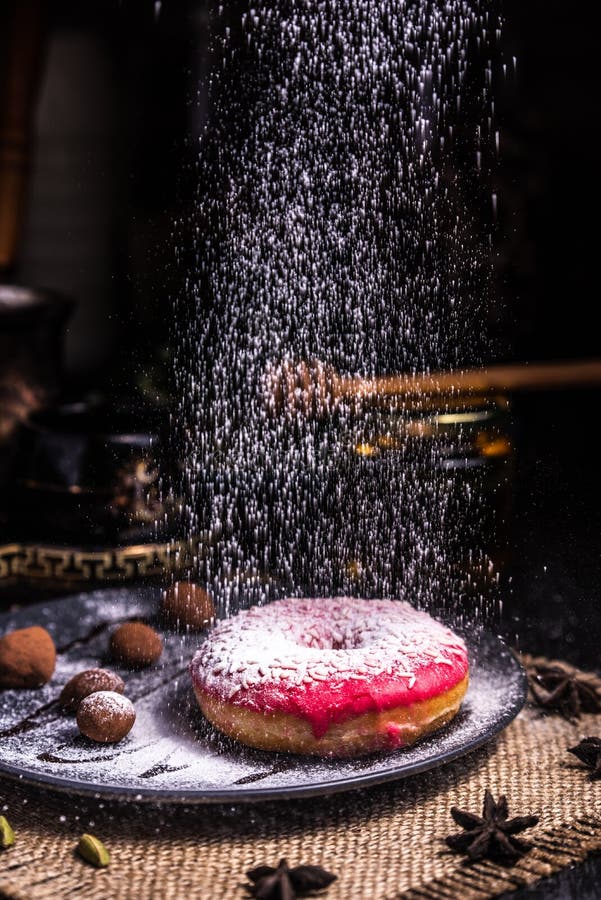 Ciambella in glassa con i dadi in un tartufo di cioccolato in un ristorante Glassa in polvere immagine stock Ciambella in glassa con i dadi in un tartufo di cioccolato in un ristorante Glassa in polvere immagine stock