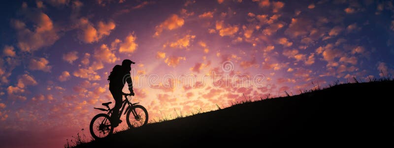 Ciclismo in salita contro un tramonto maestoso e colorato