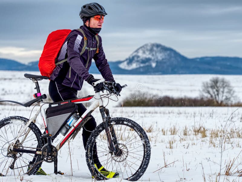 Ciclista hombre vestido con ropa de ciclismo y casco protector instala su  bicicleta de montaña en el techo del coche mientras pasa tiempo en la  naturaleza