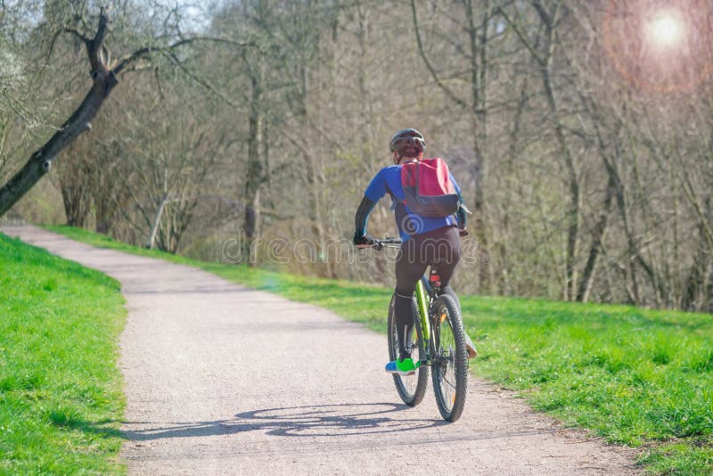 Male cyclist in helmet in a road outdoors. Healthy lifestyle and adventure concept. Sunny day, toned photo. Male cyclist in helmet in a road outdoors. Healthy lifestyle and adventure concept. Sunny day, toned photo