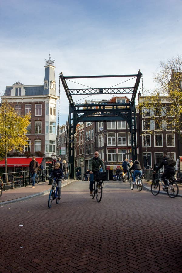 Ciclistas que cruzan un puente en Amsterdam fotografía de archivo libre de regalías Ciclistas que cruzan un puente en Amsterdam fotografía de archivo libre de regalías