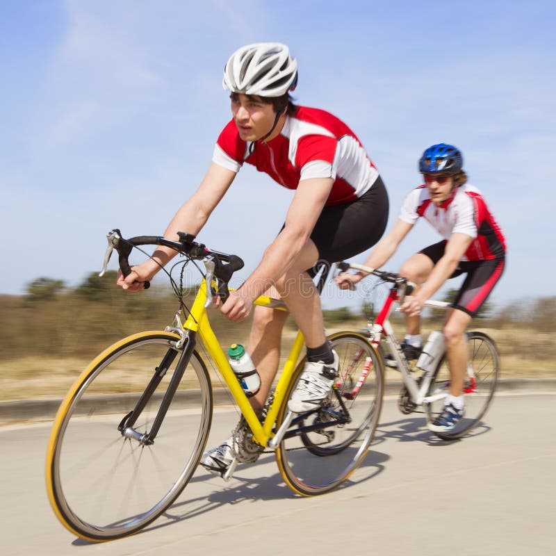 Two cyclists sprinting past the camera at high speed. Two cyclists sprinting past the camera at high speed