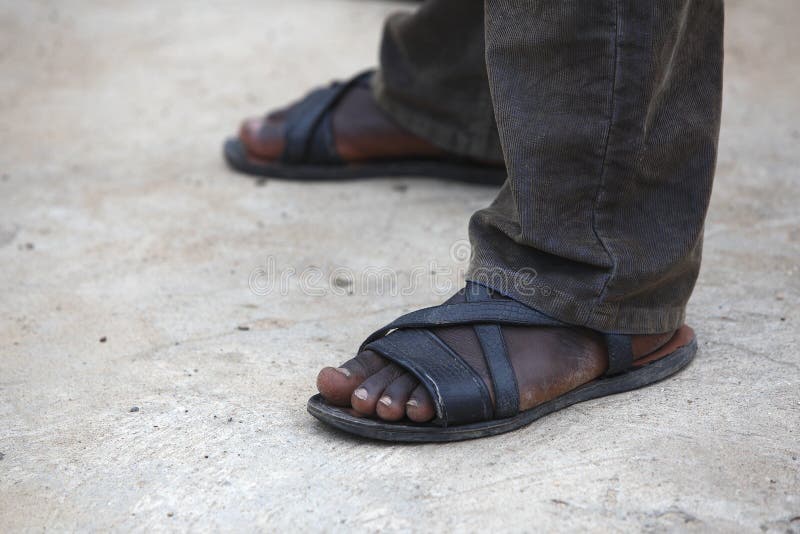 Feet of an African man with long brown trousers. Feet of an African man with long brown trousers