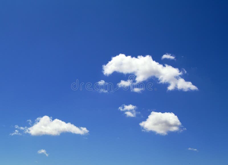 White fluffy clouds floating on a bright blue sky background on a sunny day. Summertime. White fluffy clouds floating on a bright blue sky background on a sunny day. Summertime.