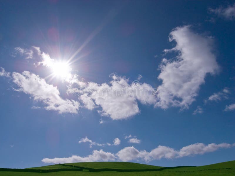 Vivid sky and field showing sun and clouds during Spring, England. Vivid sky and field showing sun and clouds during Spring, England